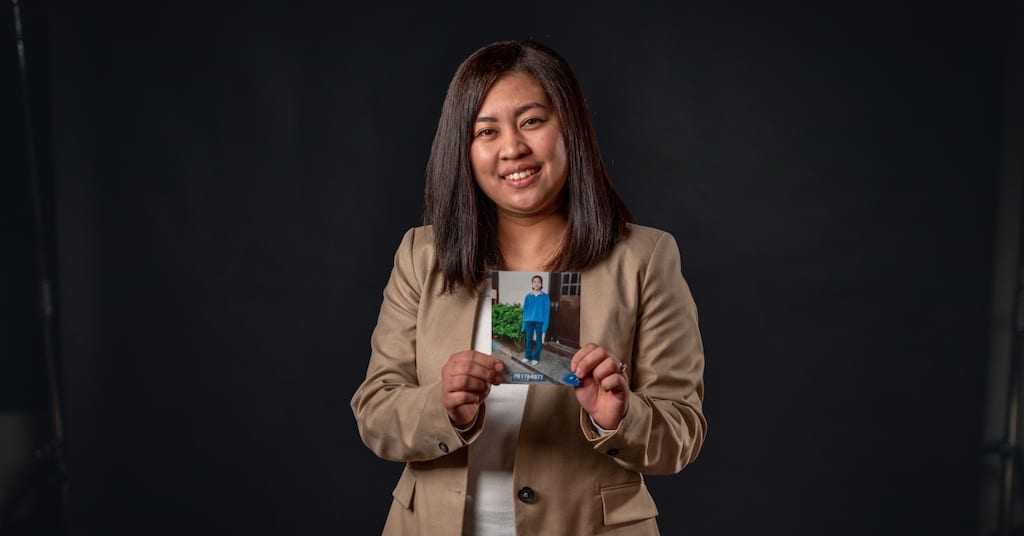 Ria holding a photo of herself as a child.
