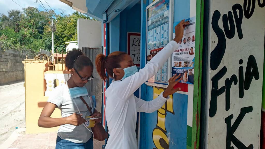 Compassion staff put up posters to raise awareness about preventing the spread of COVID-19.