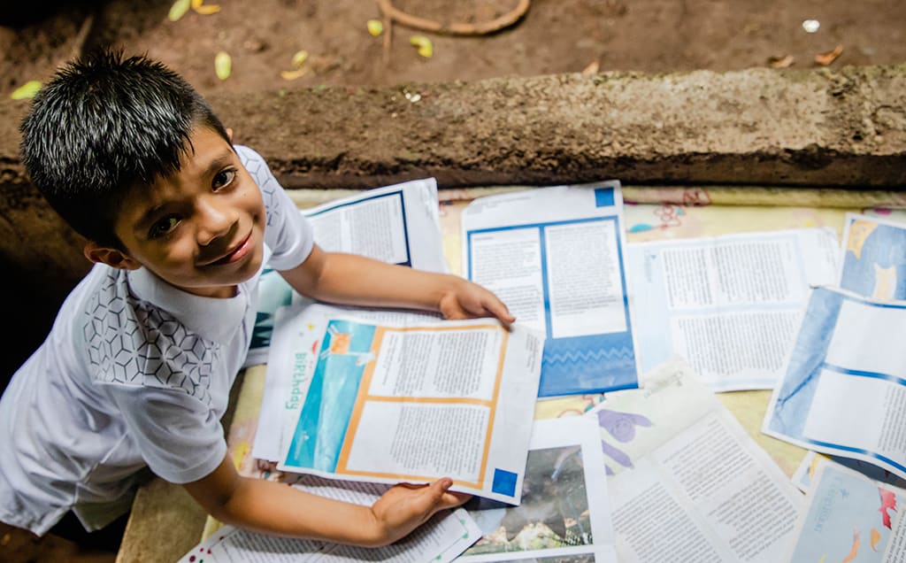 Joseph holds the letters from his sponsor and smiles up at the camera.