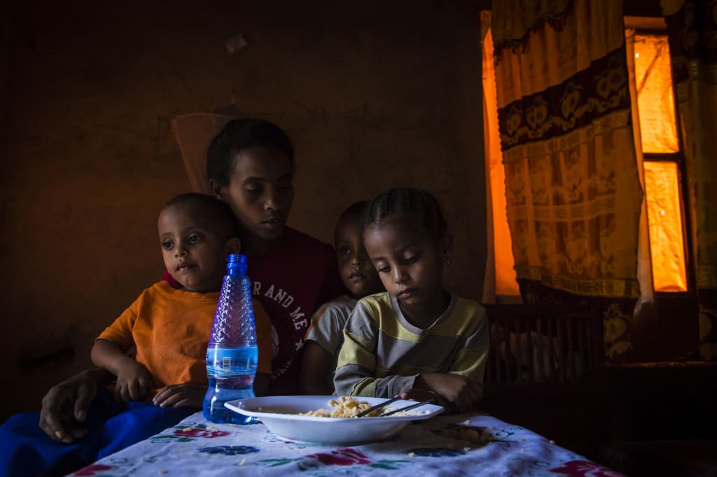 A family sits in the dark around a table