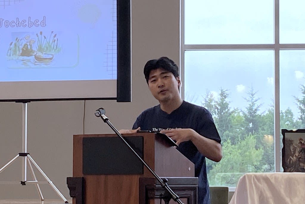 Compassion Ambassador John Park speaks at a pulpit.