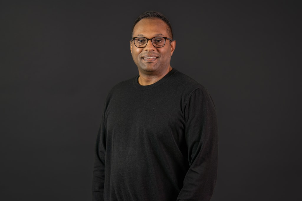 A photo of Jerry Sen, smiling and wearing a black sweater.