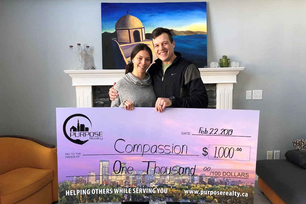 Purpose Realty clients pose with a cheque made out to Compassion.