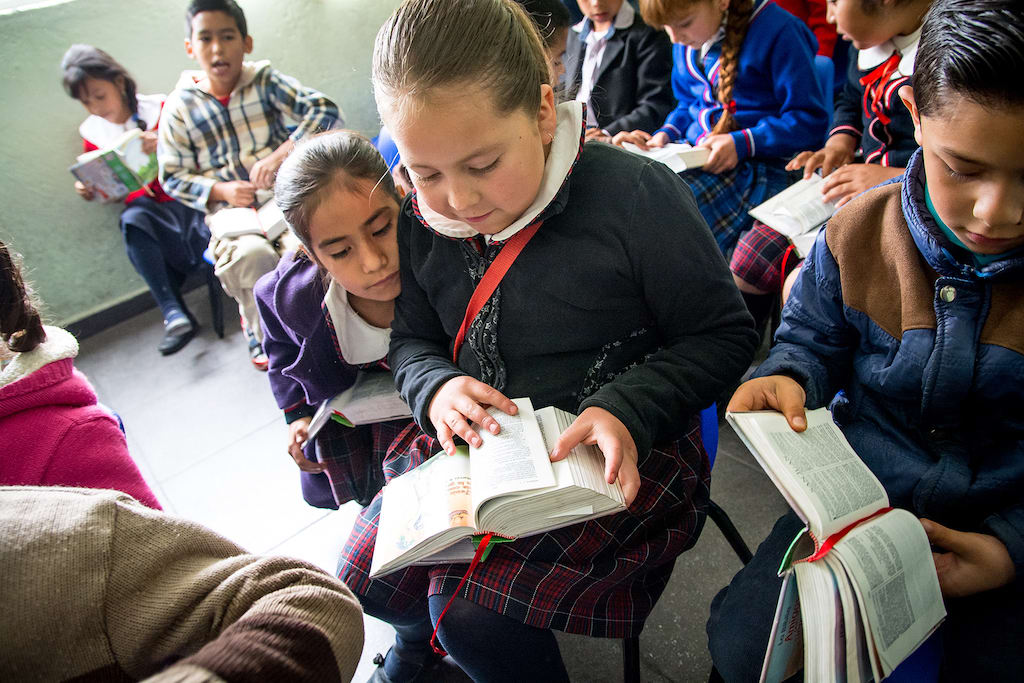 Children look at Bibles.