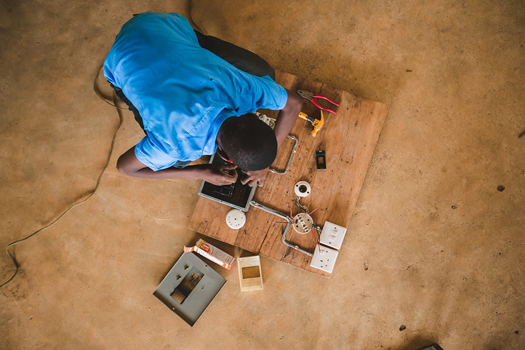 A picture taken from above of a boy working on an electrical circuit.