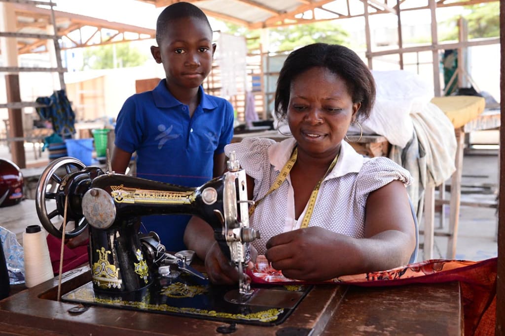 A woman works at a sewing machine.