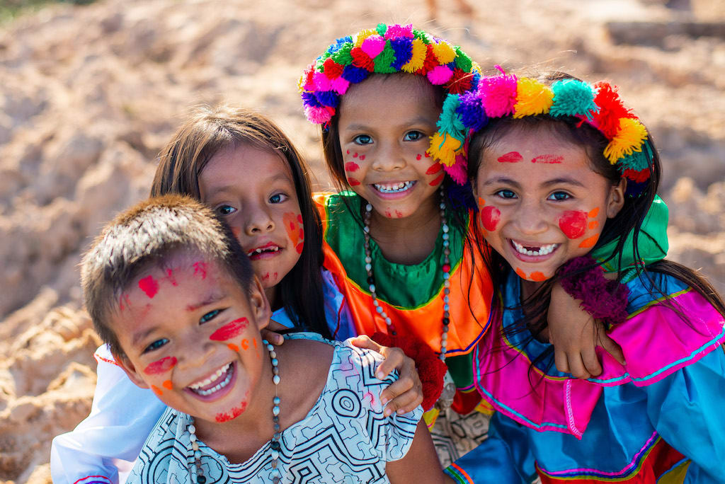 A group of four children in colourful traditional dress.