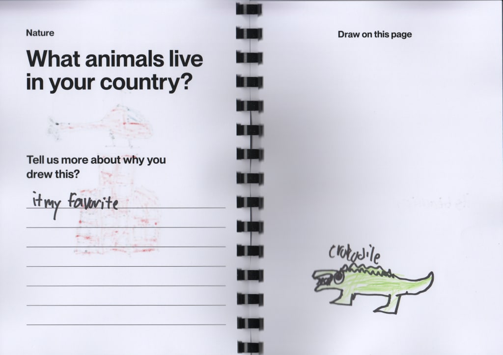 A picture of an open notebook with a drawn picture of an alligator.