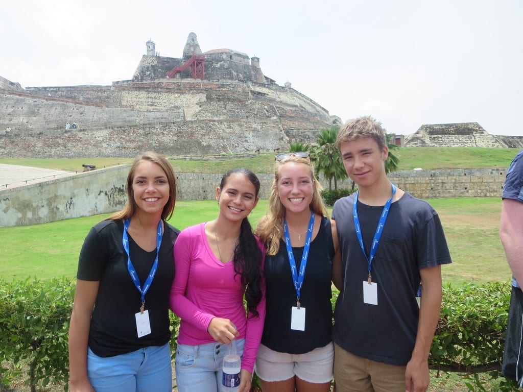 Tim Hague Sr.'s three kids with Erlise. They are standing in front of stone structure in a large field.