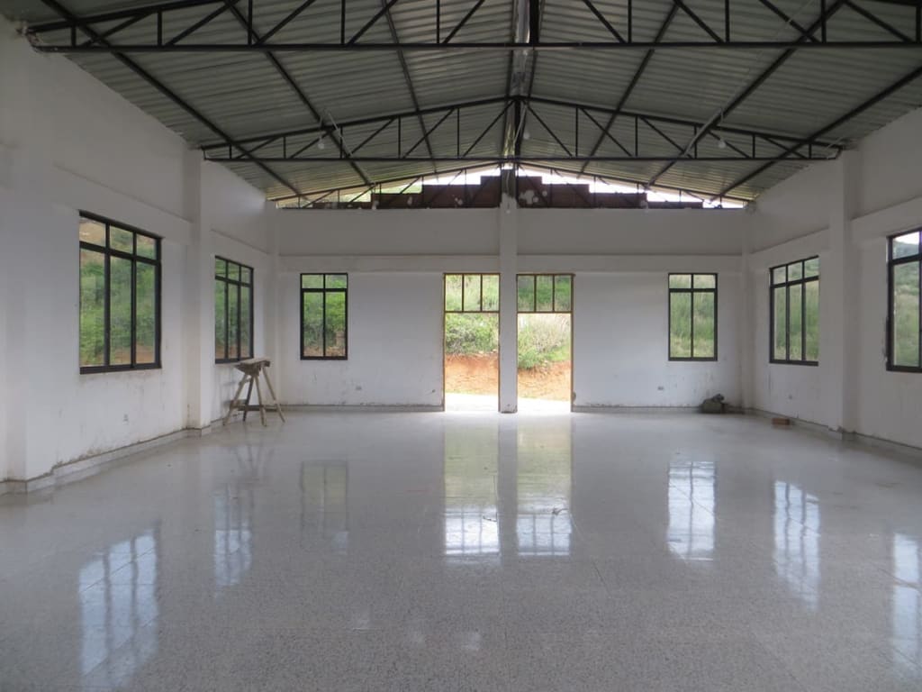 Interior view of the sanctuary showing front entrance, tile floor and steel roof.