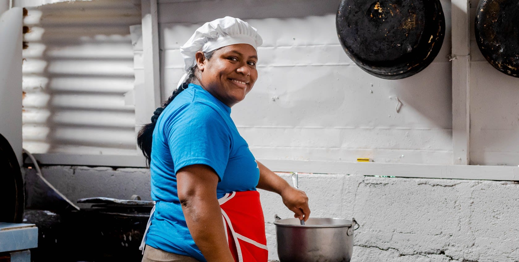 A lady wearing blue shirt and cooking