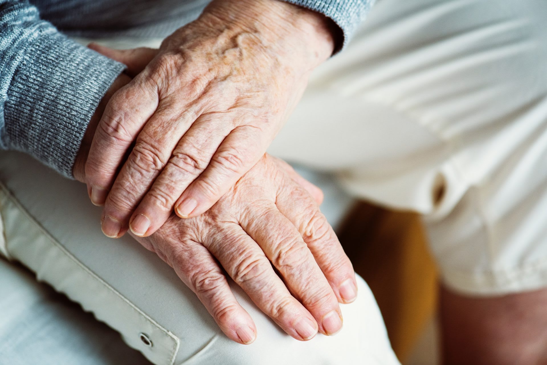 A close-up picture of an elderly woman's hands on her knees.