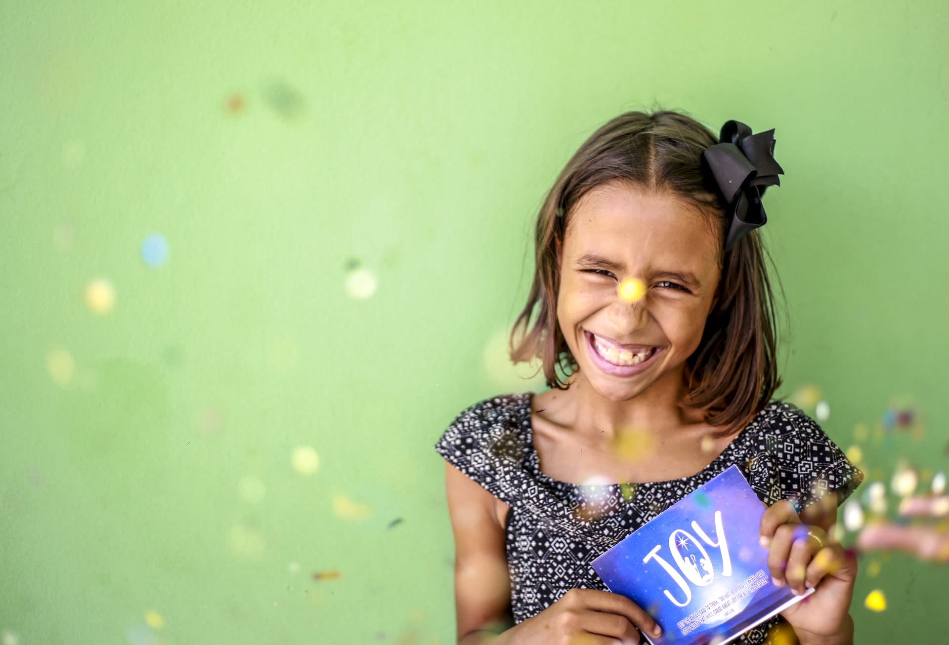 Girl holding a card that says: Joy
