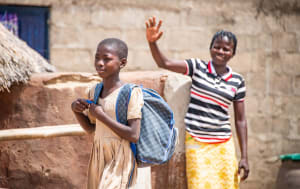 Mother waving her daughter goodbye