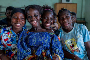 A group of girls sitting together smiling