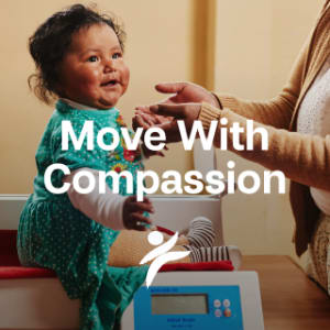 A picture with a toddler smiling, with the words "Move With Compassion" and a logo overlaying the picture.
