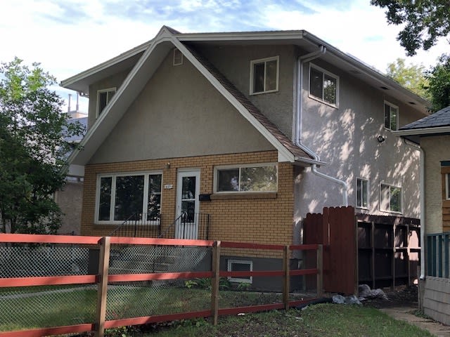 A picture of Lynn's' house from a side profile. There is a red fence on the side.