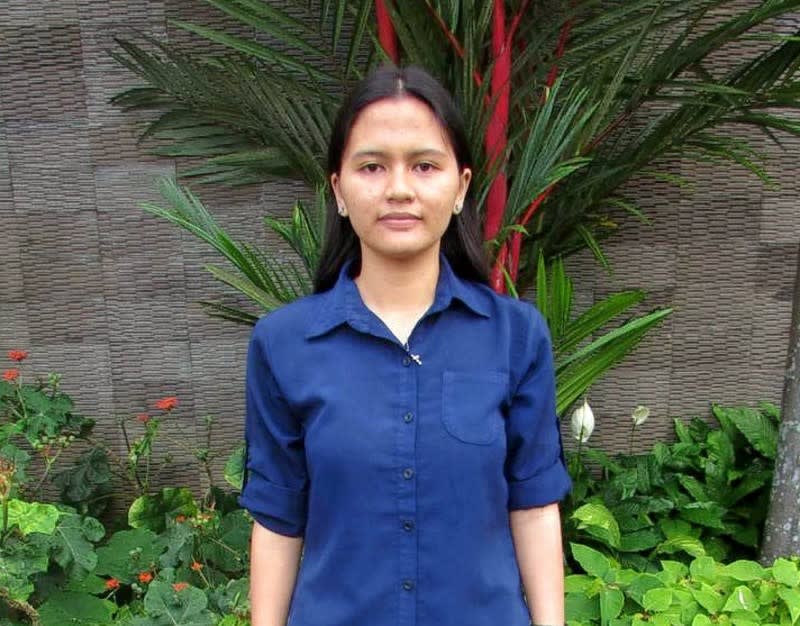 A girl in a navy shirt looks at the camera