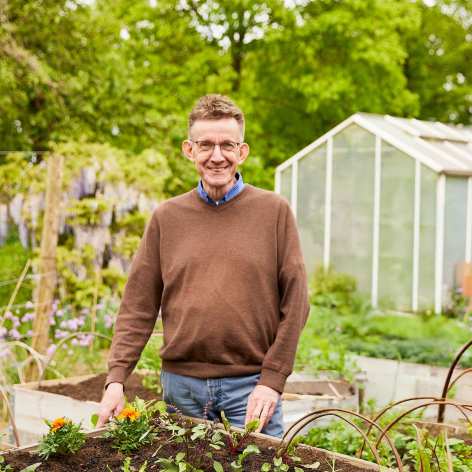Gartenexperte Werner Peitzmann hinter einem Hochbeet stehend im Garten