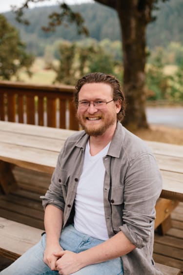 President Ryan Faddis sitting at a picnic table beneath a tree