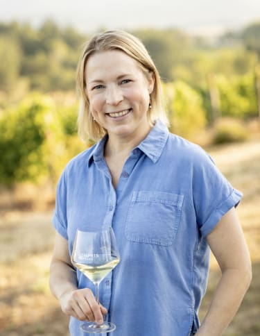 Erin Allen is outside of the boutique tasting room, she enjoys the philanthropic nature of our community and small winery.