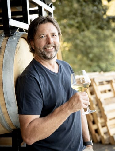 Owner Dru Allen outside the production space at Compris Vineyard, who enjoys making and sharing premium wines with our community.