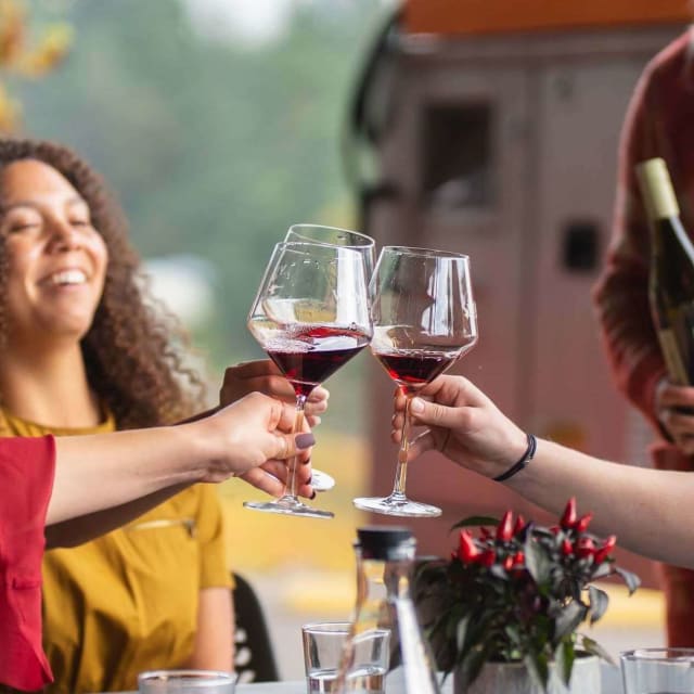 Friends proposing a toast with Pinot Noir wine at the tasting room of the hidden gem, Compris Vineyard.