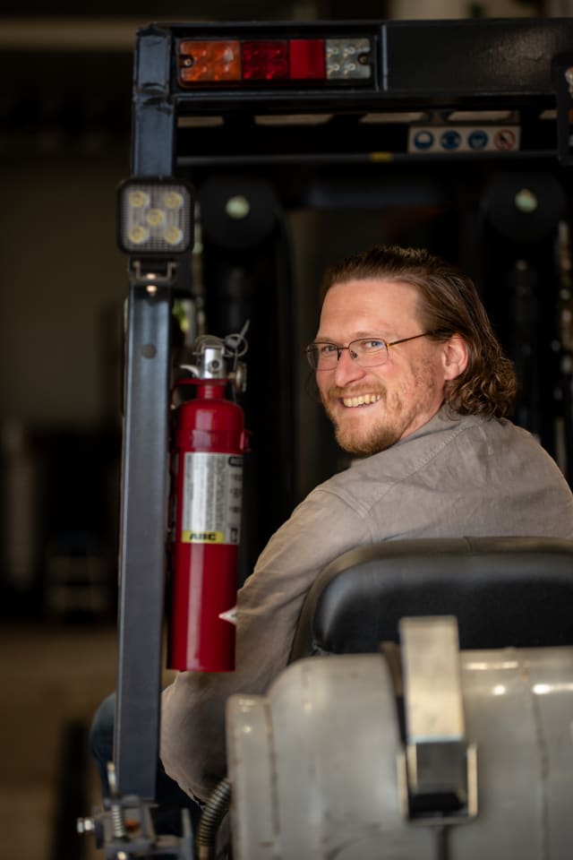 President Ryan Faddis in the production space on a forklift.