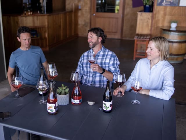 The small winery team of Aaron, Dru, and Erin around a table at their boutique tasting room just outside of Newberg.