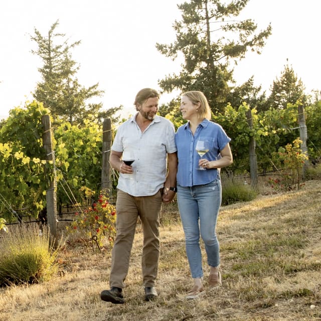 Compris Vineyard proprietor's Dru and Erin Allen, walking in the vineyard as the sun sets outside of Newberg, Oregon.