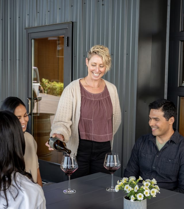 Danielle pouring Pinot Noir wine tastings for guests on the covered patio.