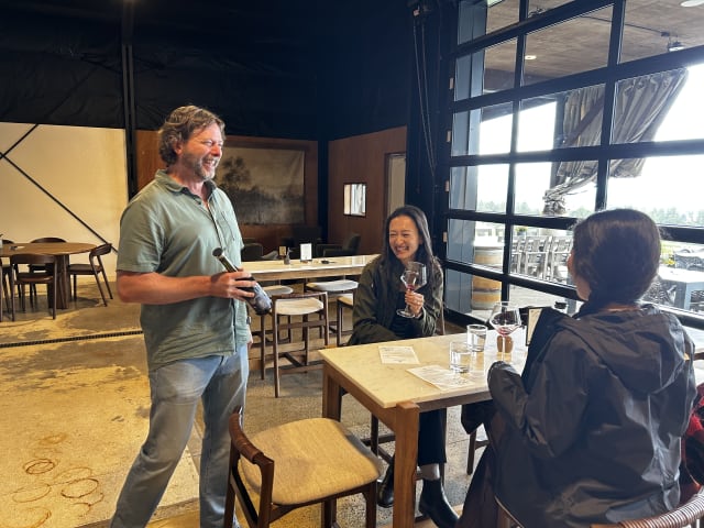 Slide Image. Winegrower Dru Allen inside the tasting room with two happy guests.
