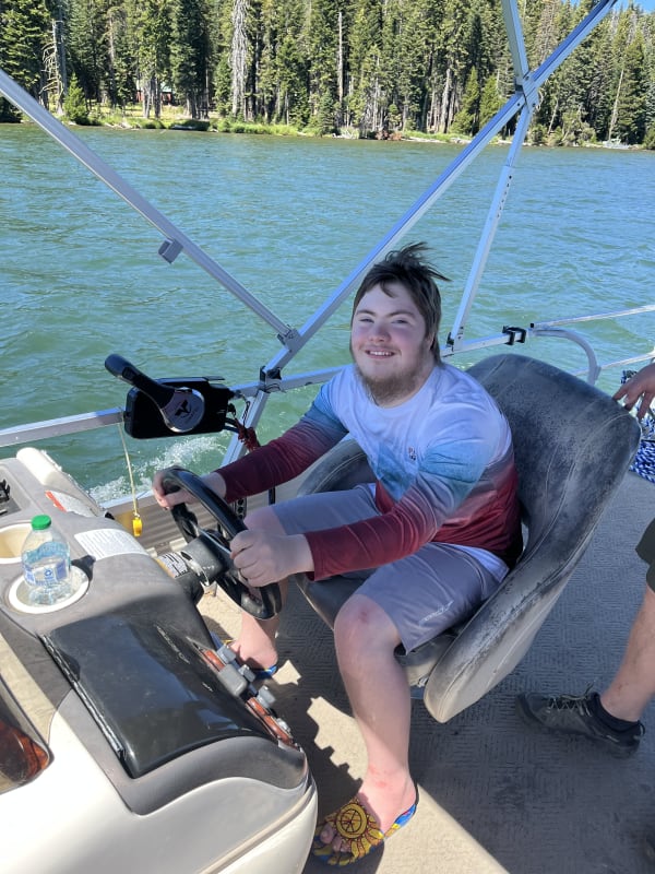 Teen-age boy drives a boat