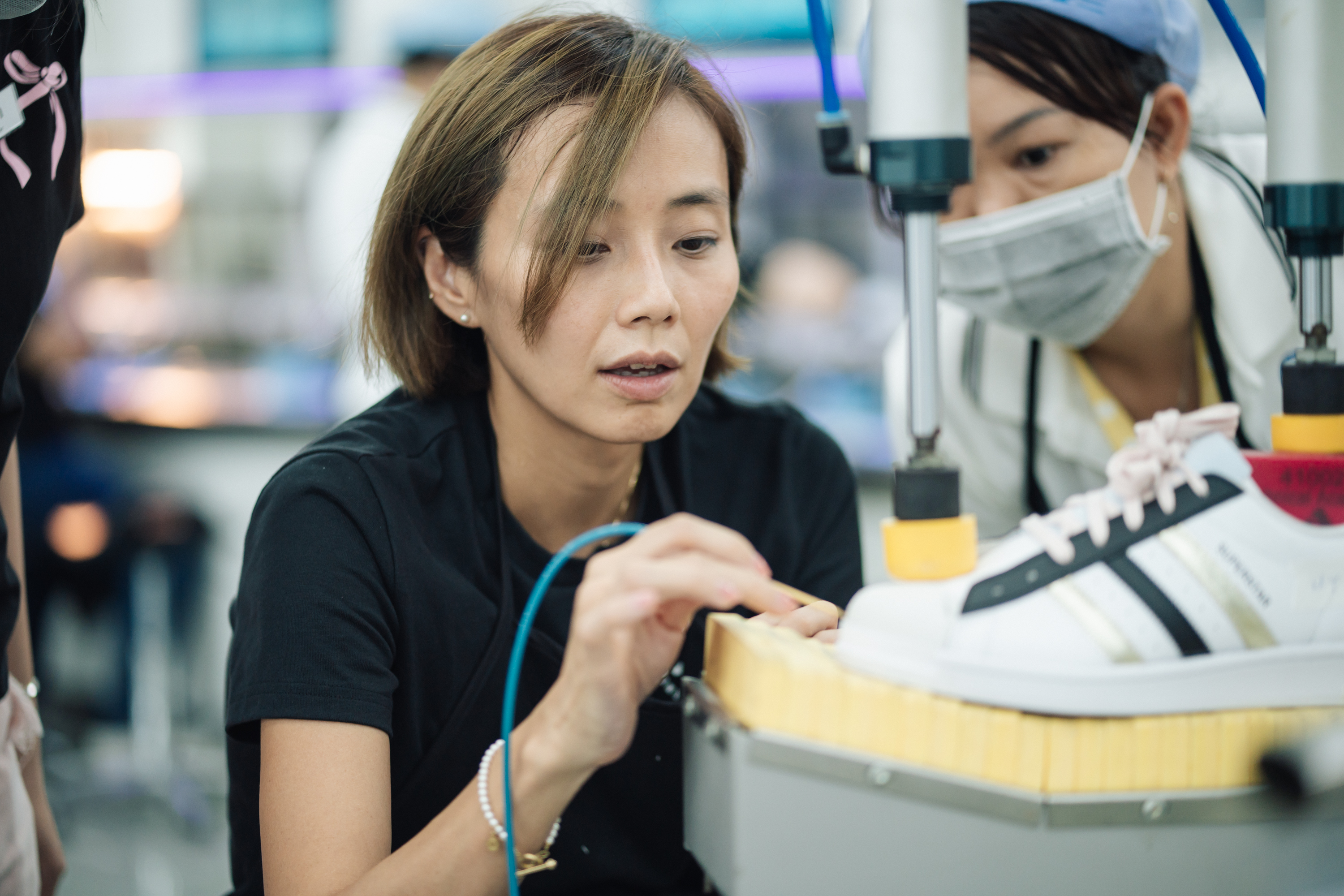 Close-up of a woman constructing a shoe.