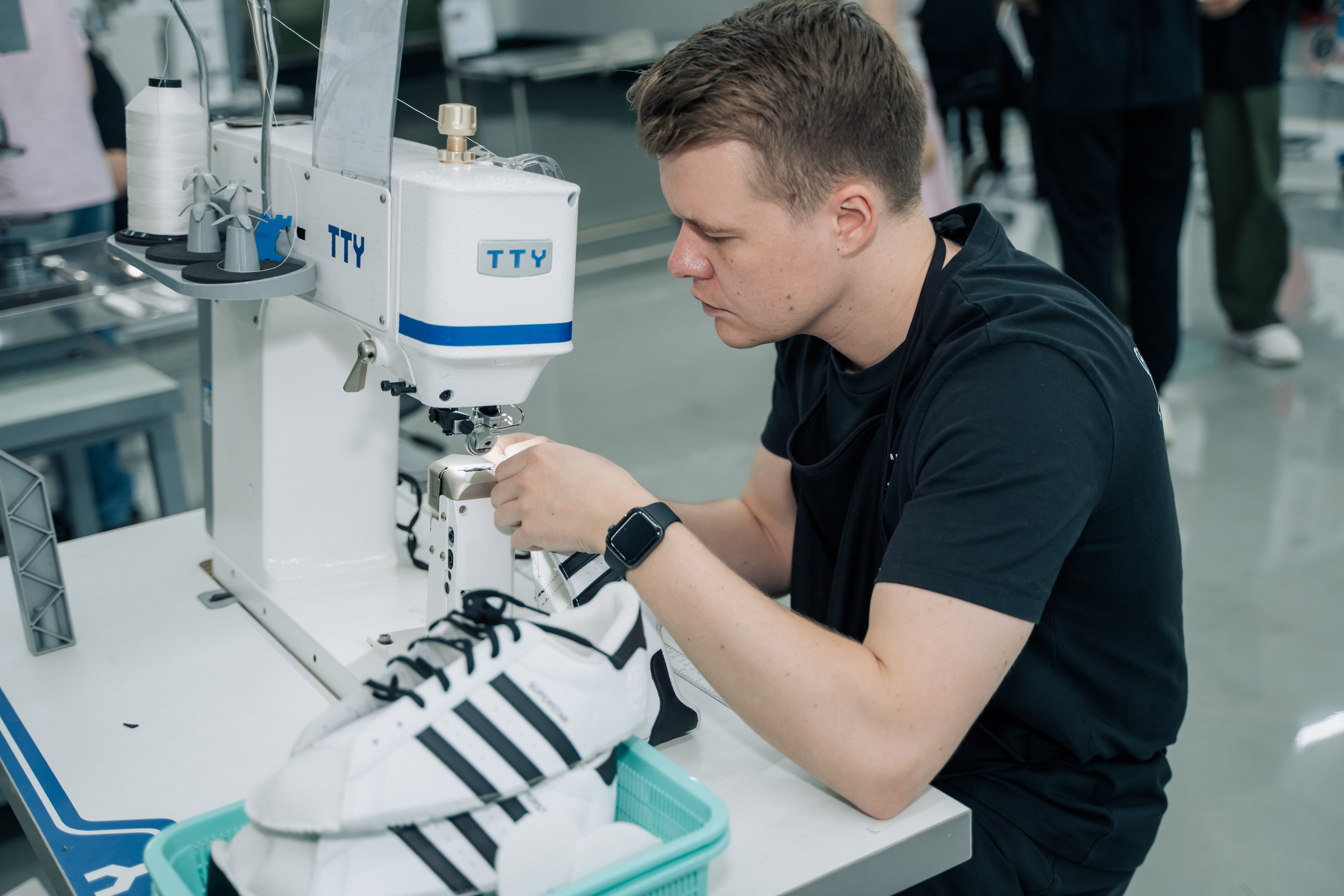 A man sews a shoe on a sewing machine