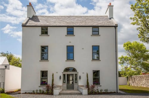 SANDYFORD HOUSE RENOVATION AND NEW BUILD Sandyford House is located in the heart of Sandyford Village, South County Dublin, on a mature, private, regularly shaped 0.3-acre (0.12-hectare) plot. Originally dating from the late 1700s, the house has undergone extensive renovations and now comprises a detached four-bedroom home spanning 2,508 sq. ft. (233 sq. m.). The original structure has been carefully restored, renovated, and extended, with skilled craftsmen from across the country enlisted to reinstate as many original features as possible.

The design concept aimed to establish a visual connection between Sandyford House and the proposed new single-story dwelling. The form, scale, and positioning of this dwelling are inspired by traditional linear extensions, one of the most common approaches to creating additional accommodation. Located immediately south of Sandyford House, the proposed contemporary dwelling features a screened front elevation facing Sandyford Road and a side elevation facing the main house. In contrast, the rear façade is largely glazed, offering views of the expansive private garden.

Carefully positioned and designed, the contemporary dwelling maintains the architectural “rhythm” and symmetry of the primary residence. Its subservient form ensures that it does not compromise the overall scale, proportions, or character of Sandyford House, preserving its historical integrity.