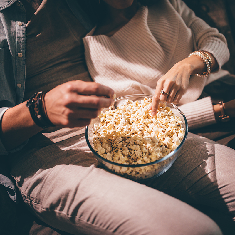 Couple on couch eating popcorn