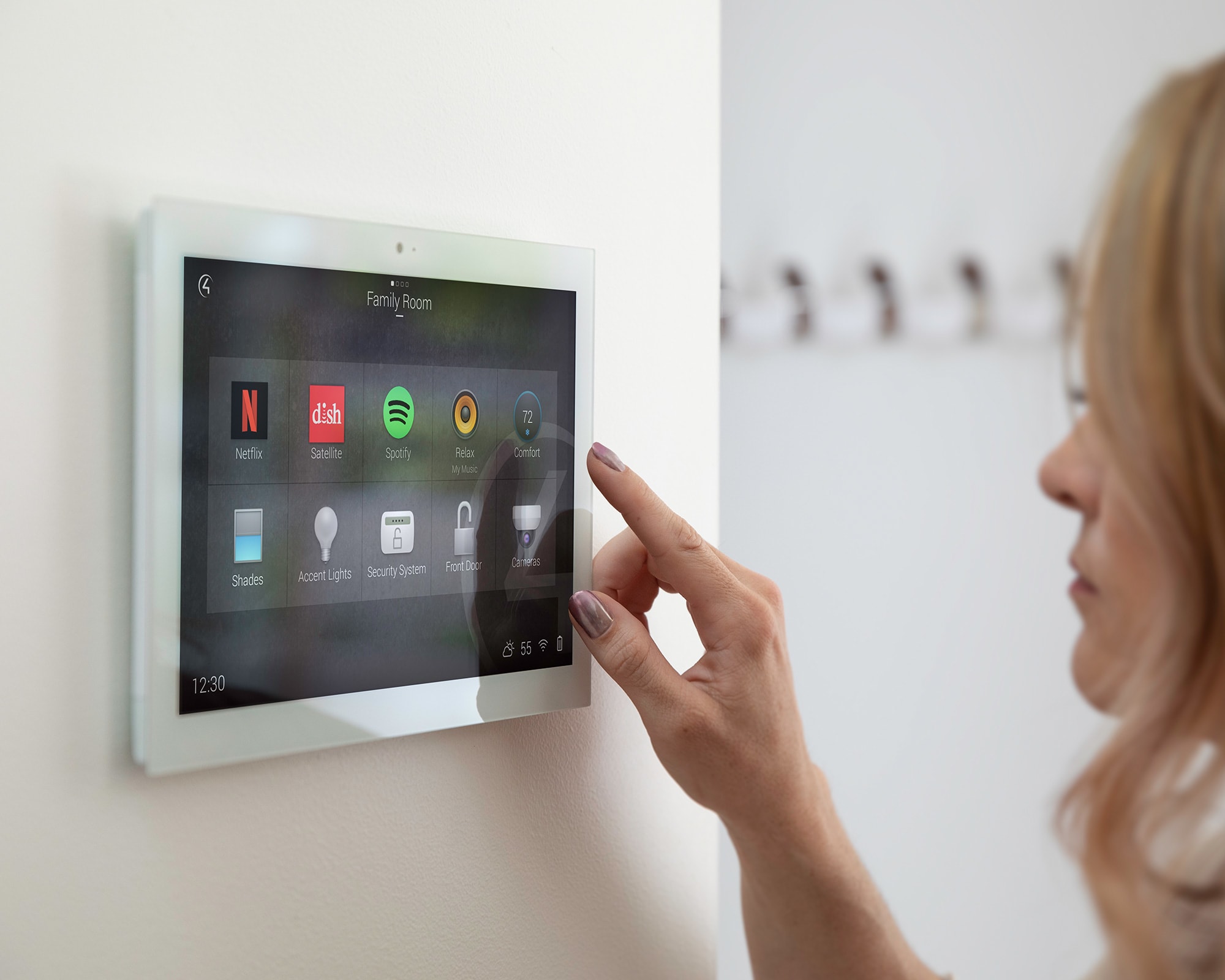 Mujer interactuando con Control4 Smart Home OS 3 en una pantalla táctil en la pared