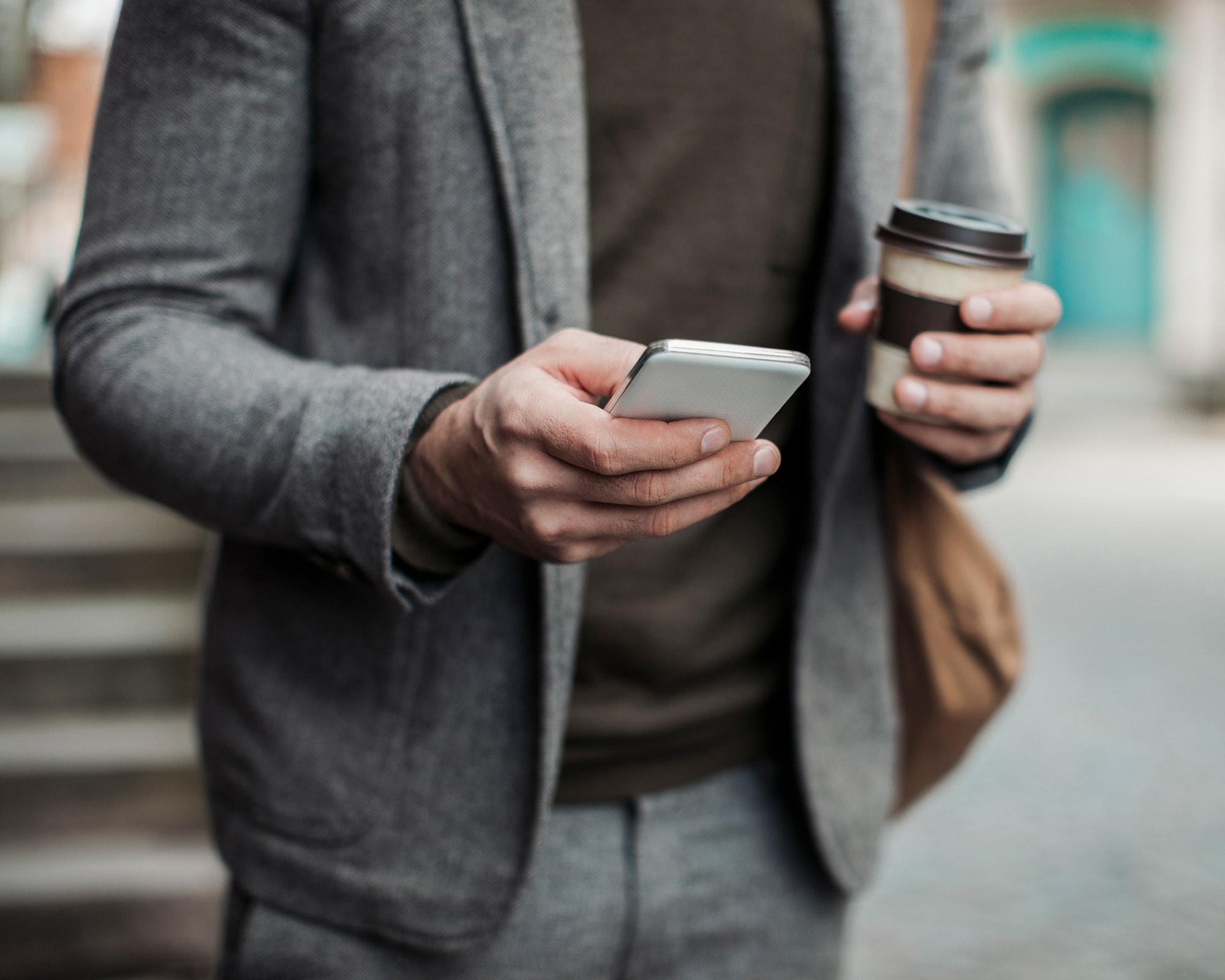 Man holding smart phone outside