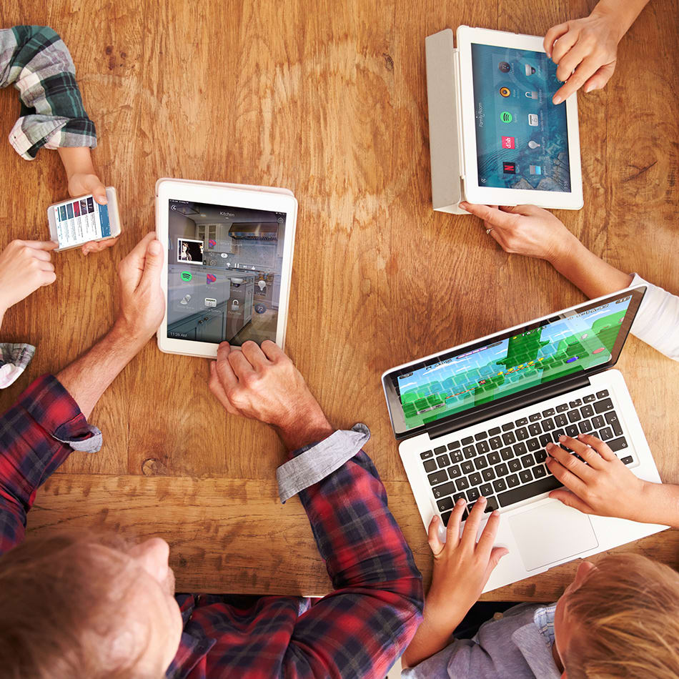 Top down view of people collaborating work on various devices