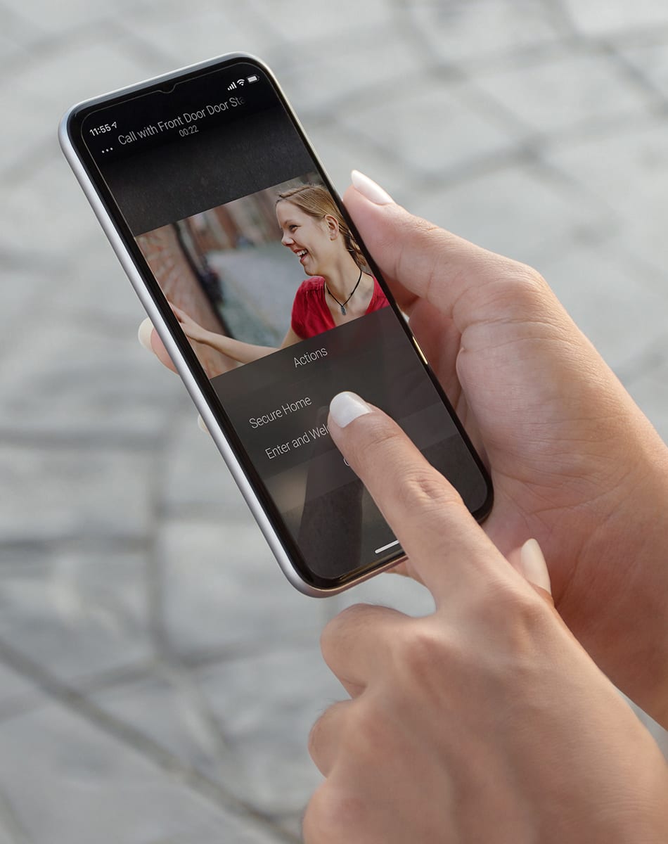 Person holding a phone pressiong a button to secure their home