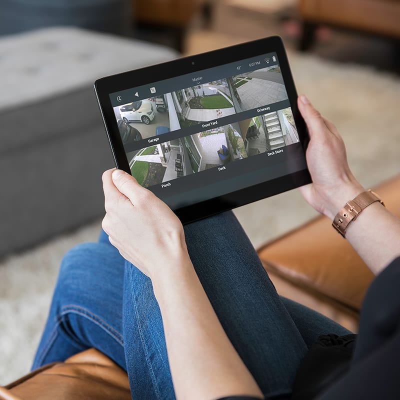 Person sitting holding a tablet with security camers in view