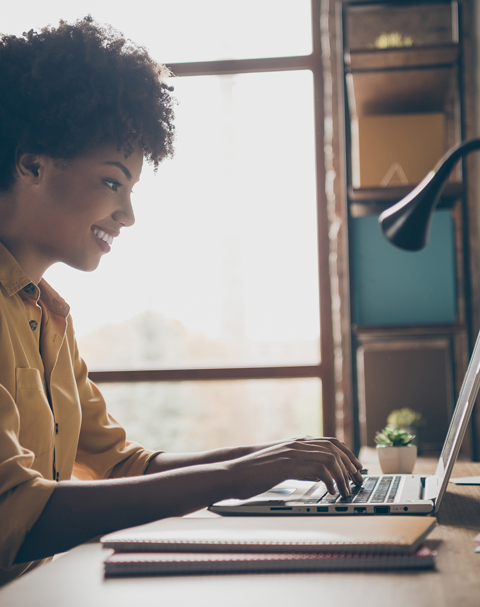 Woman smiling working on laptop at home