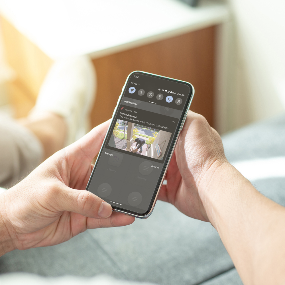 Person holding phone watching live feed of security system