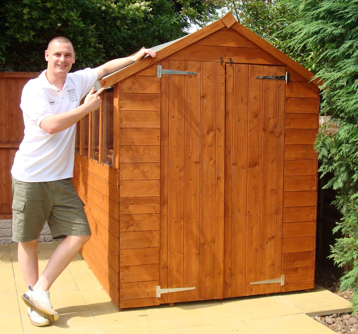 A photo of Ben next to his assembled shed.