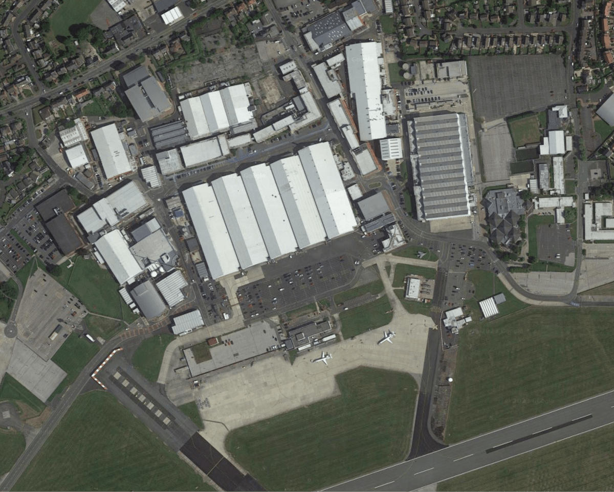 Aerial view of an aircraft assembly facility. Jet aircraft look tiny next to the huge structure!