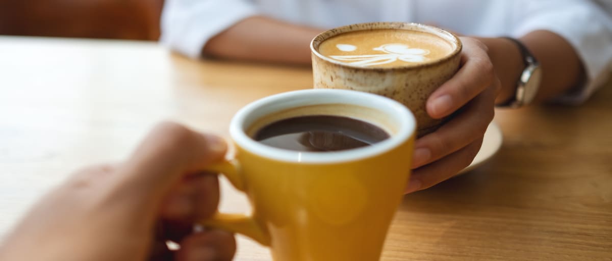 A photo of two people drinking coffee together.