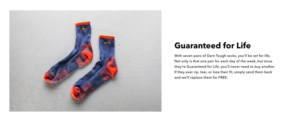 A pair of blue and orange Darn Tough socks beside the headline “Guaranteed for Life” describing the lifetime replacement promise.