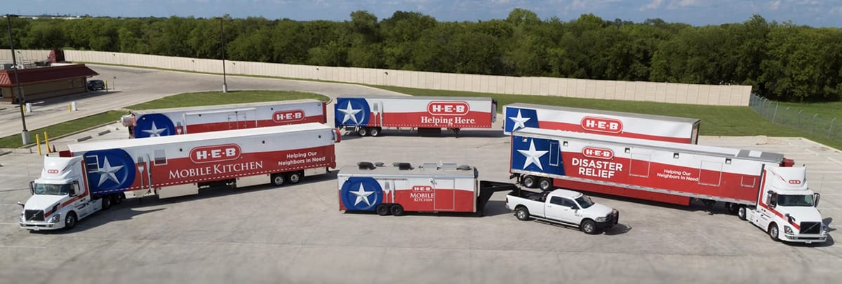 A lineup of H-E-B disaster relief and mobile kitchen trucks arranged in a semicircle, ready for community support.