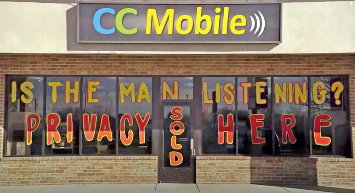 A huge painted sign across a small mall store reads: ‘IS THE MAN LISTENING? PRIVACY SOLD HERE.’